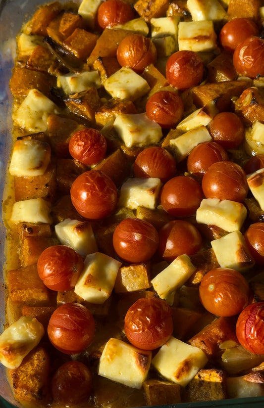 roasted pumpkin, baby tomato, halloumi and risoni in a baking tray hot out of the oven.